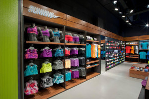 Parete espositiva con scarpe e abbigliamento running e grafica a parete verde