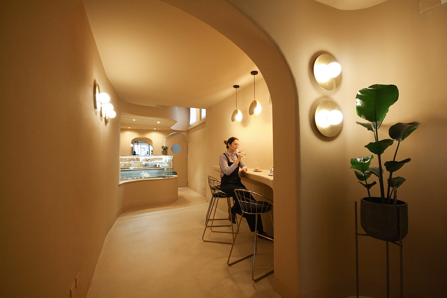 Seating area with rounded walls and warm lighting, Cannoncino pastry shop Piacenza