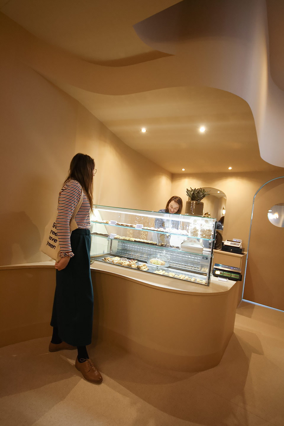 Customer at the counter of Cannoncino pastry shop, organic interior design Piacenza