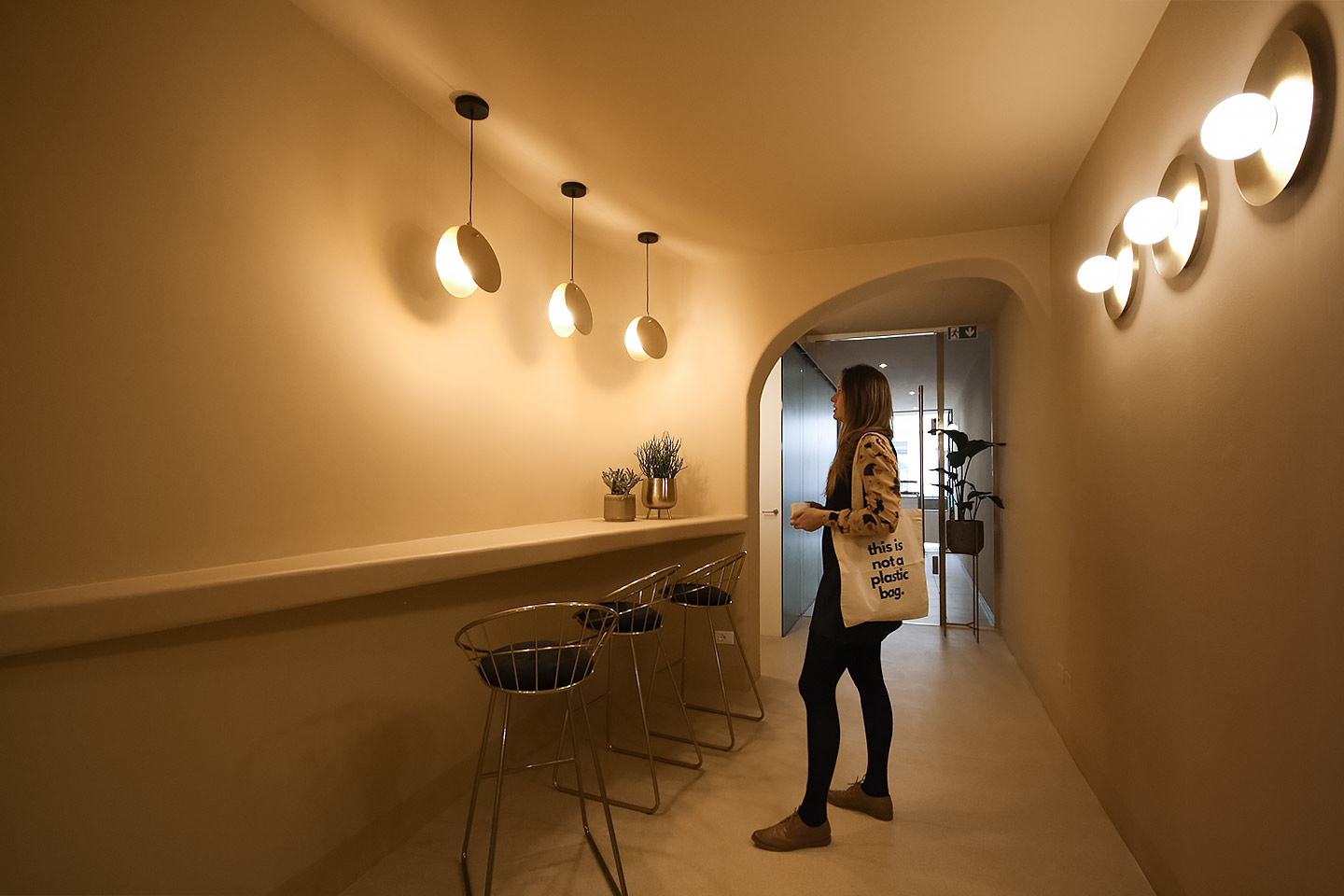 Interior view of Cannoncino pastry shop Piacenza, curved cream-coloured walls and brass lighting