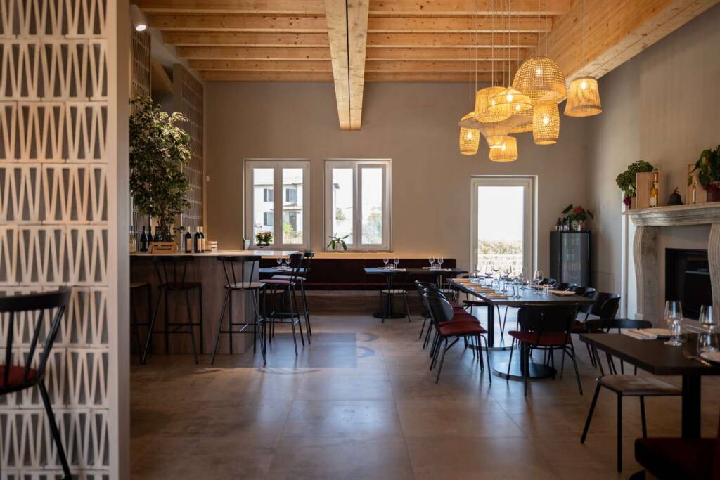 campana di ferro sala ristorante con sedute in velluto bordeaux, celosie particia urquiola, gruppo di lampadari in vimini e ficus benjamin