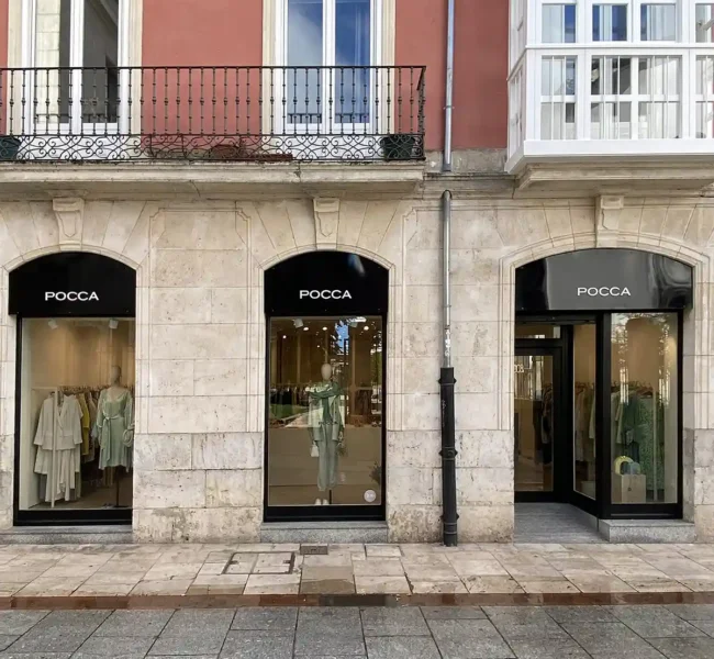 Pocca boutique entrance with mannequin and herringbone parquet floor — retail design Burgos