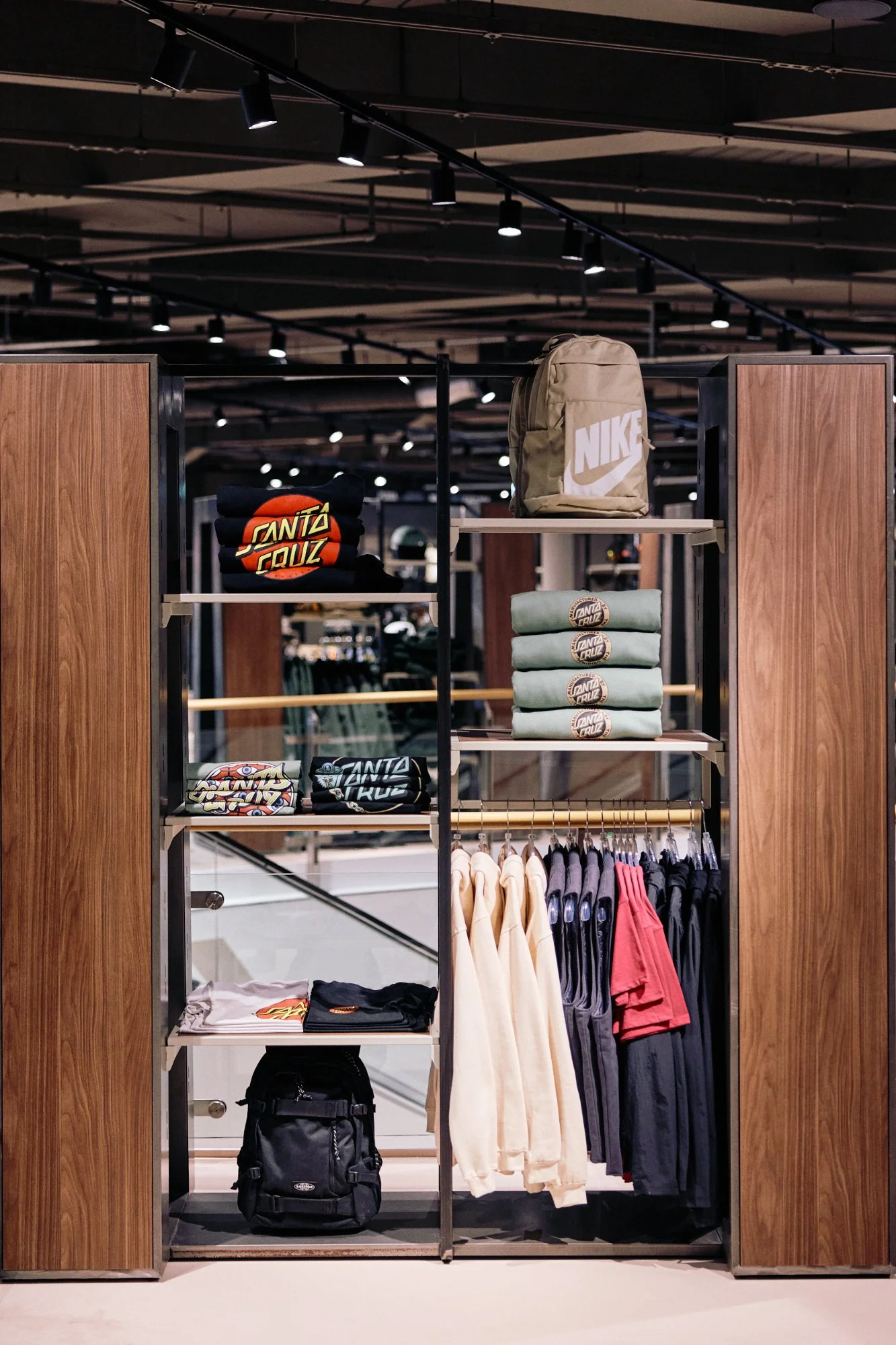 Shop-in-shop su misura con pannelli in noce e scaffalature metalliche — flagship SportScheck Dortmund, piano uomo, VANDA Designers 2025