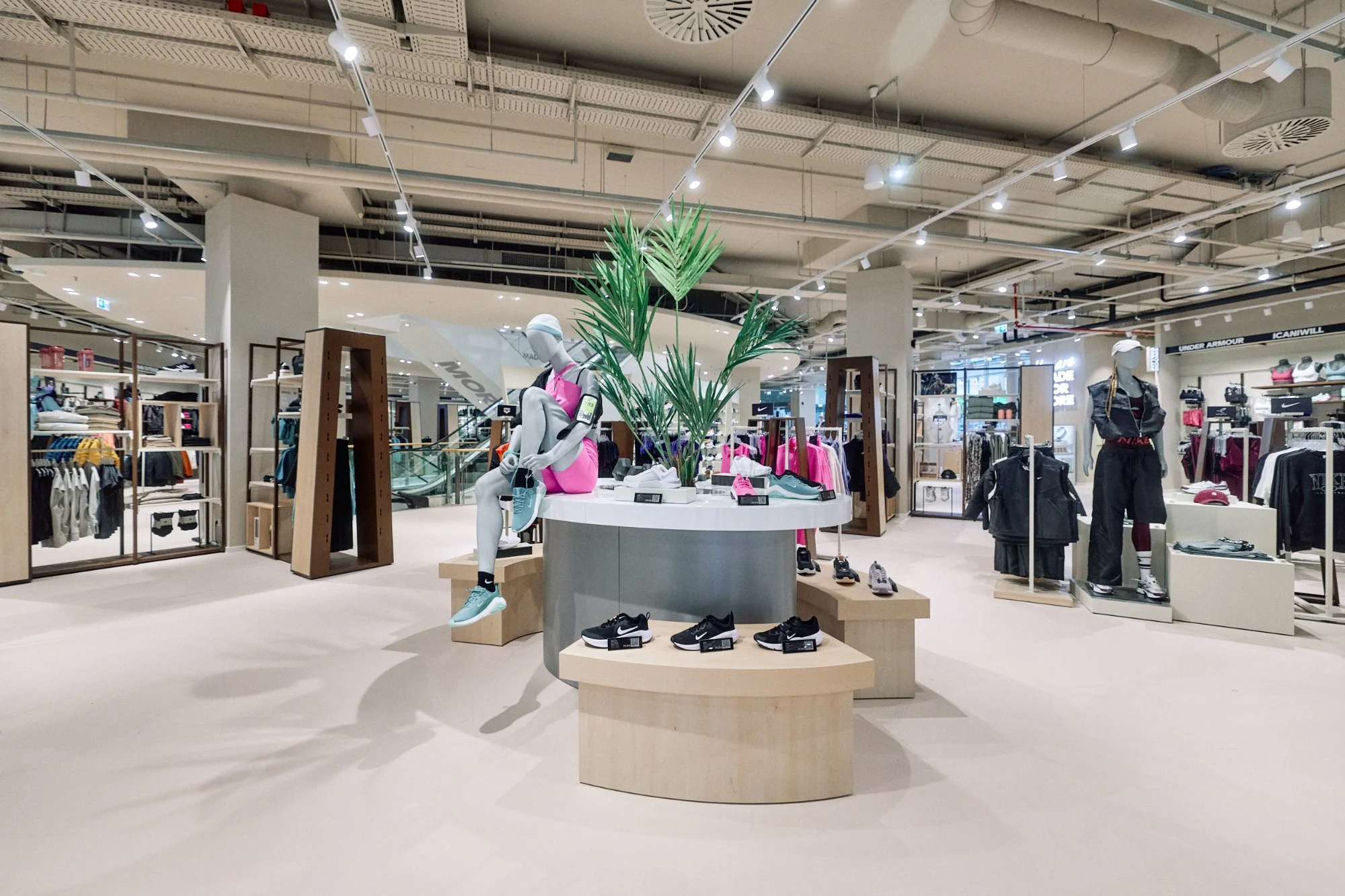 Podio centrale ovale e isola espositiva Nike — piano terra flagship SportScheck Dortmund, VANDA Designers 2025