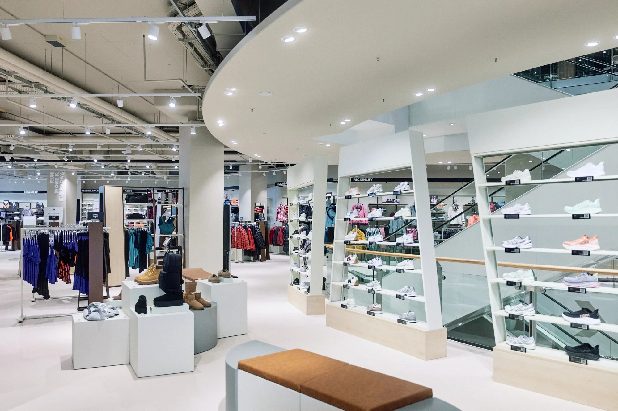 Vista generale piano terra con soffitto ovale e torri espositive scarpe su misura — flagship SportScheck Dortmund