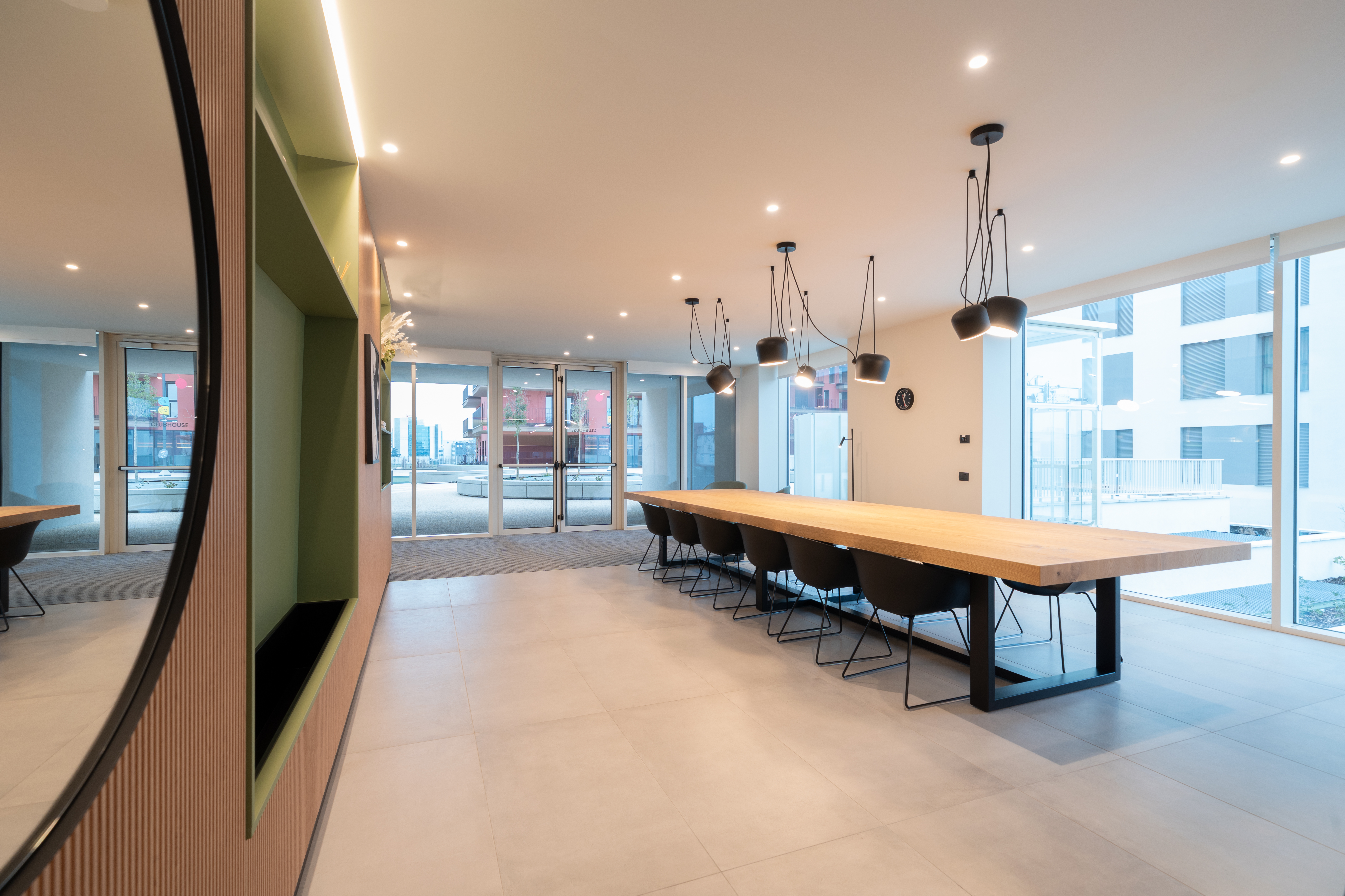 LivinUp SeiMilano clubhouse, sala con tavolo da 16 posti e vista sulla città, interior design amenities Milano