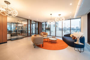LivinUp SeiMilano coworking, relaxation area with orange seating and natural light, interior design amenities Milan