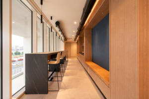 LivinUp SeiMilano coworking, corridor with linear lighting and dark wood surfaces, interior design amenities Milan