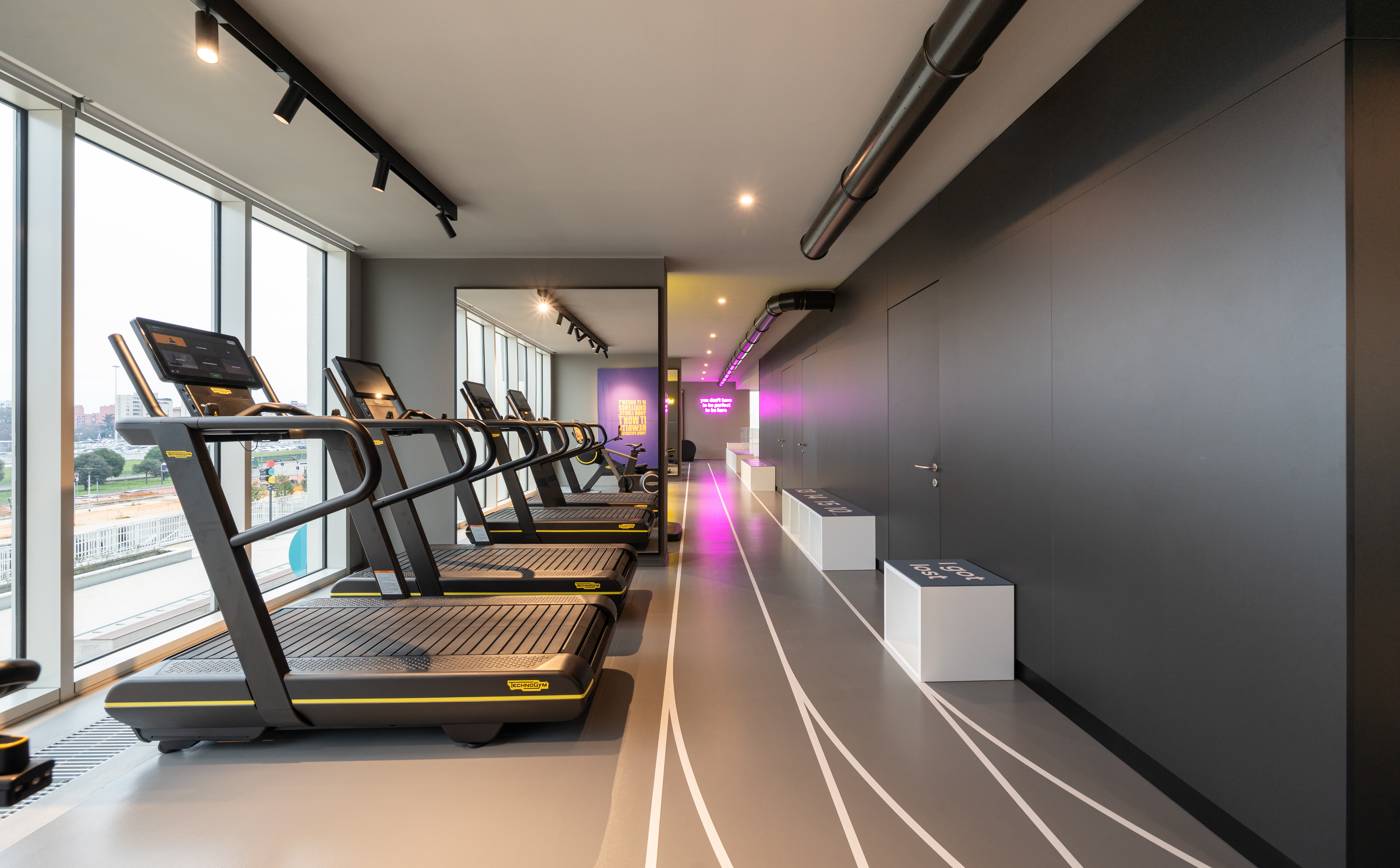 LivinUp SeiMilano gym, view with Technogym equipment and Neonsfeer lighting, interior design amenities Milan