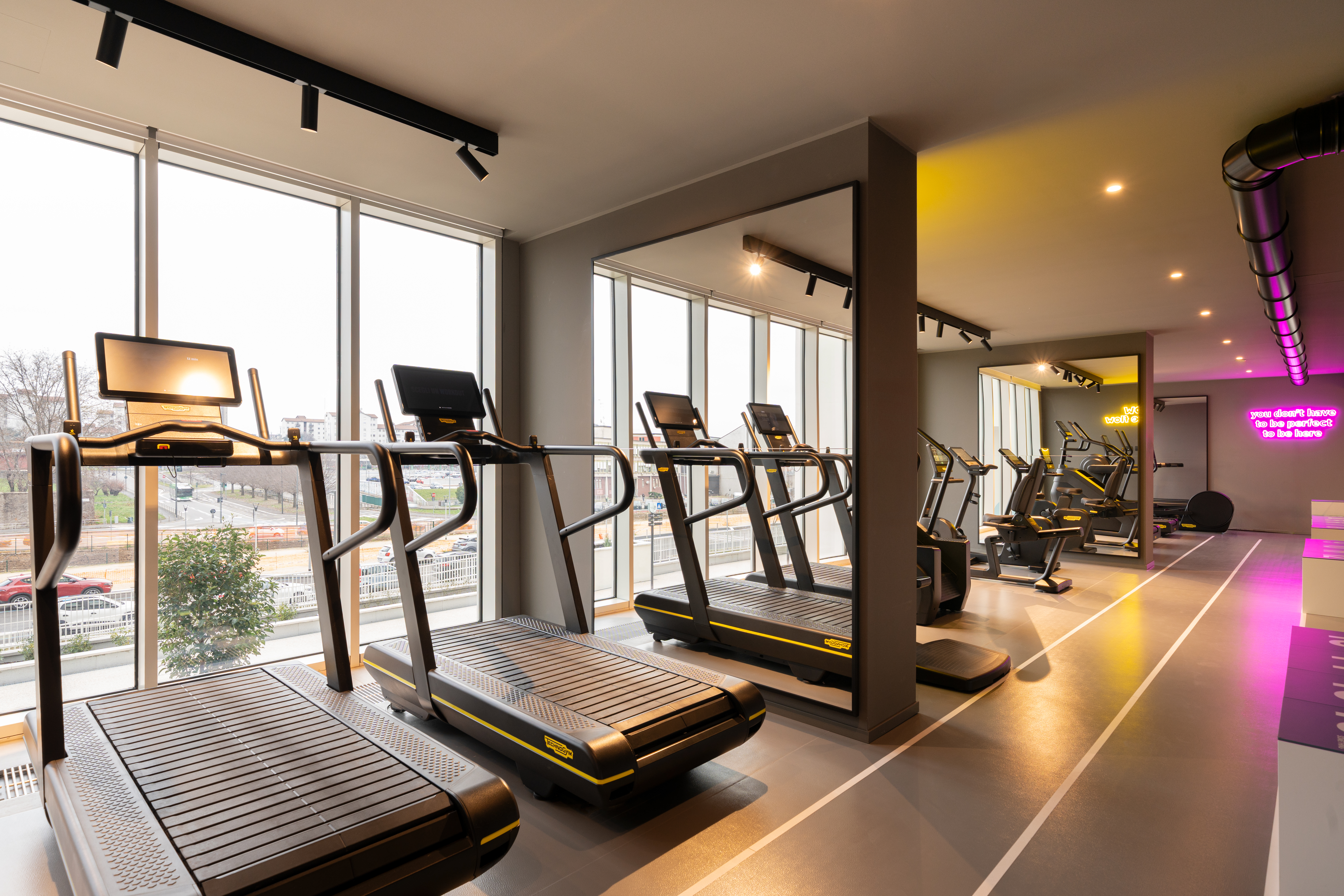LivinUp SeiMilano gym, running track and treadmills with purple neon lights, interior design amenities Milan