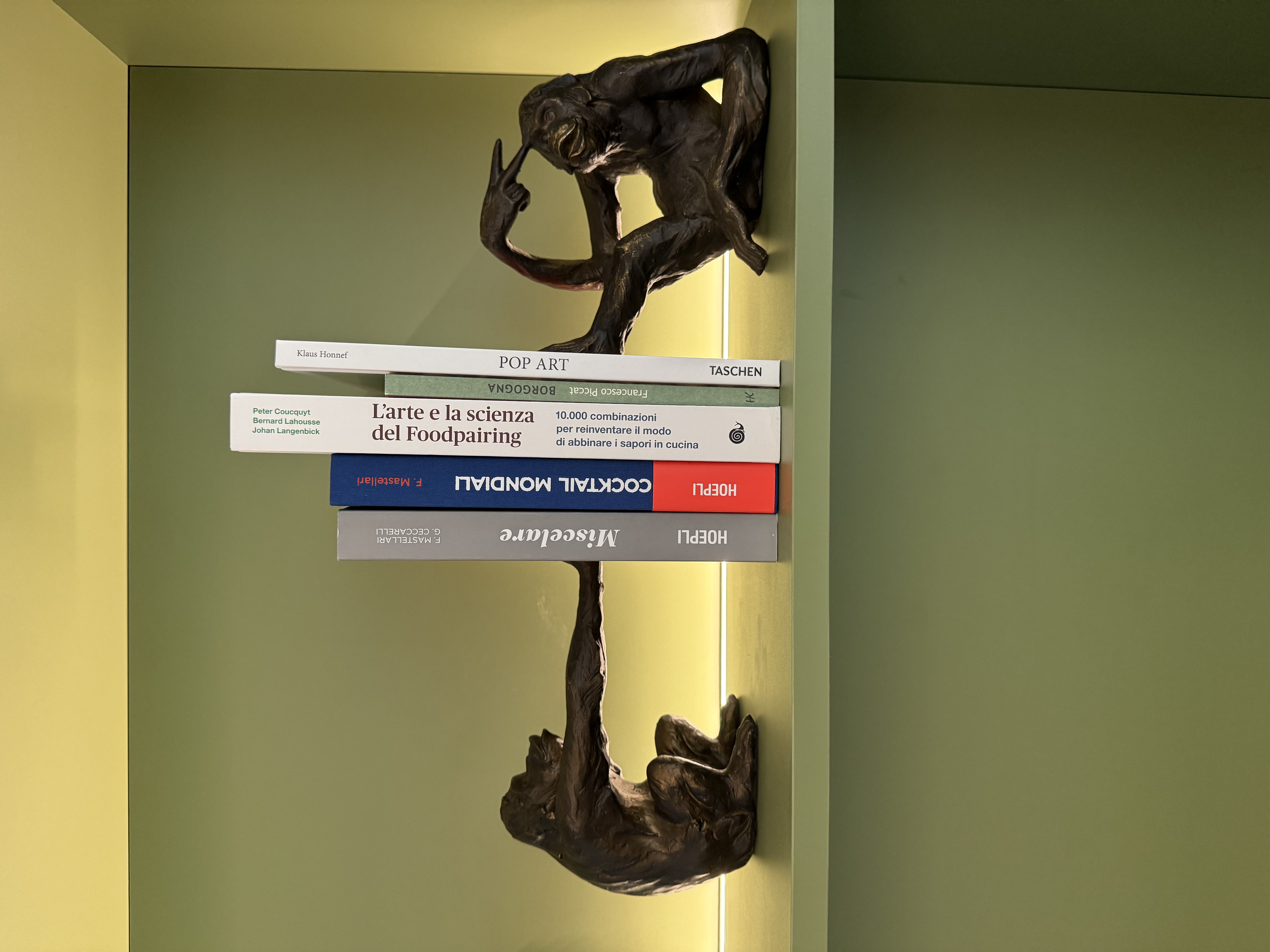 LivinUp SeiMilano clubhouse, dettaglio libreria con sculture bronzee e libri, interior design amenities Milano