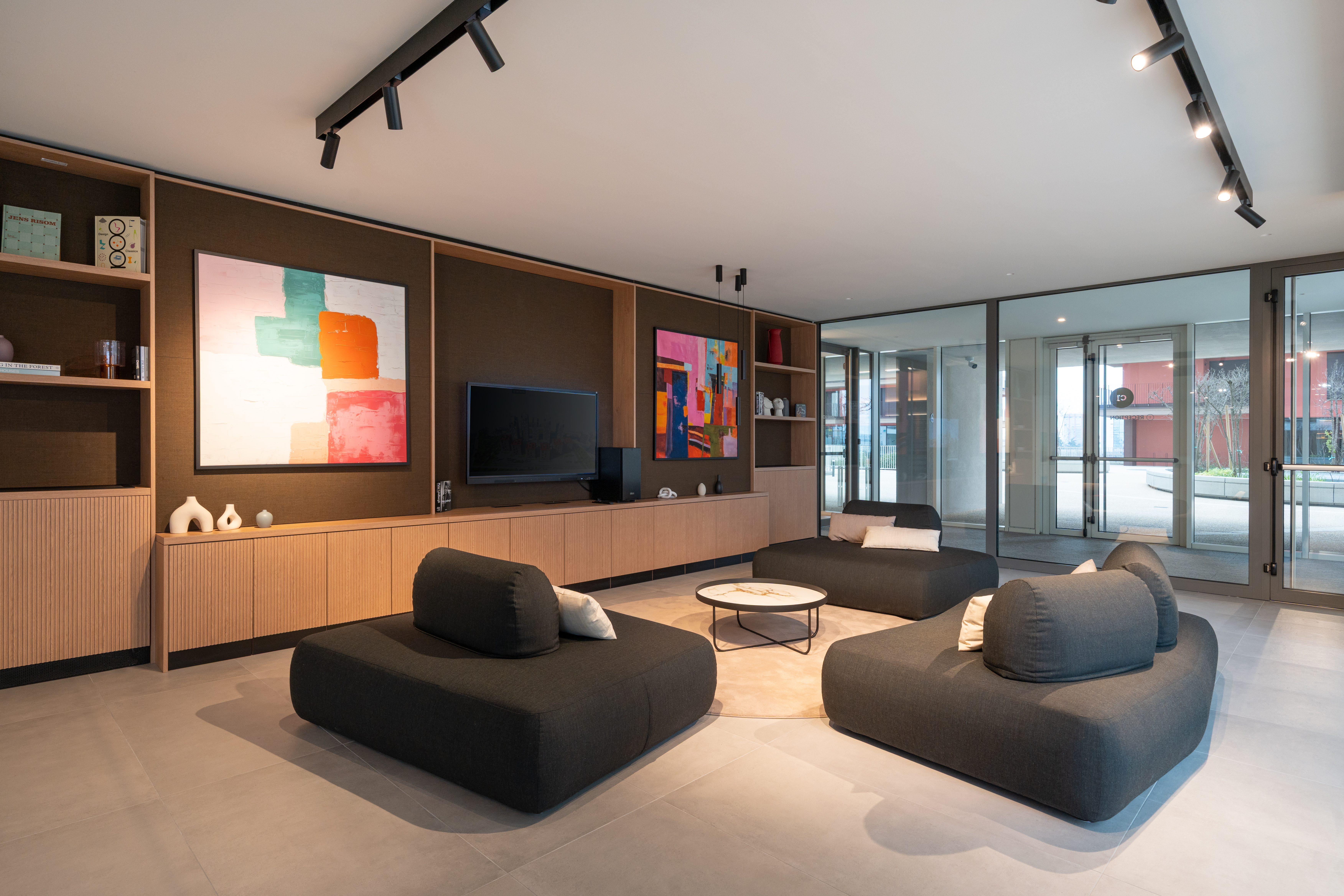 LivinUp SeiMilano portineria, vista d'angolo con sedute Westwing e parete vetrata, interior design amenities Milano