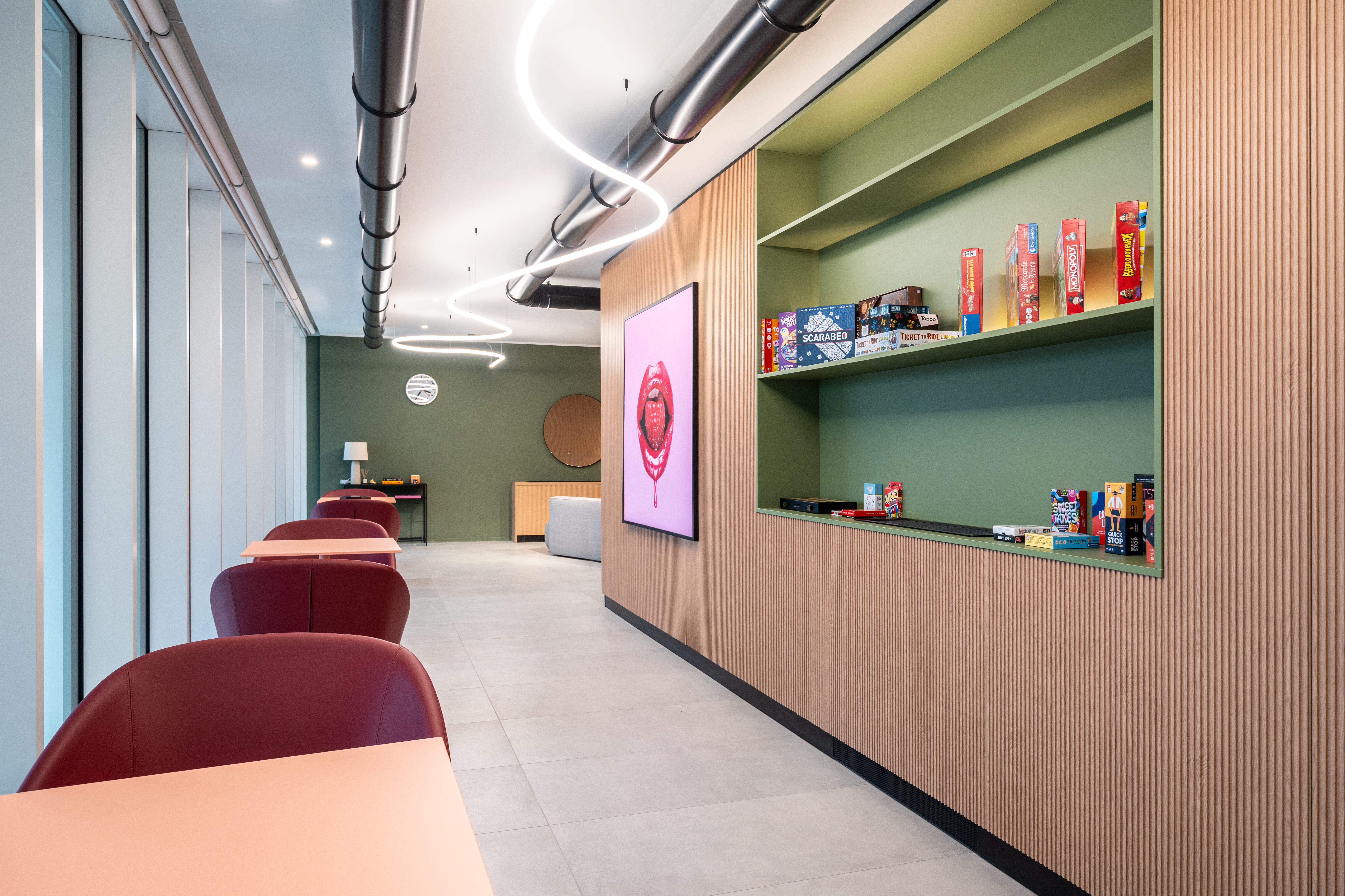 LivinUp SeiMilano clubhouse, area lounge al piano inferiore con sedute rosso ciliegia, interior design amenities Milano