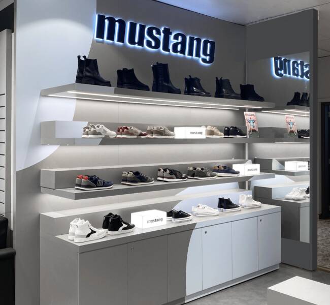 Mustang shop-in-shop at El Corte Inglés Madrid with backlit logo and illuminated shelves, VANDA project