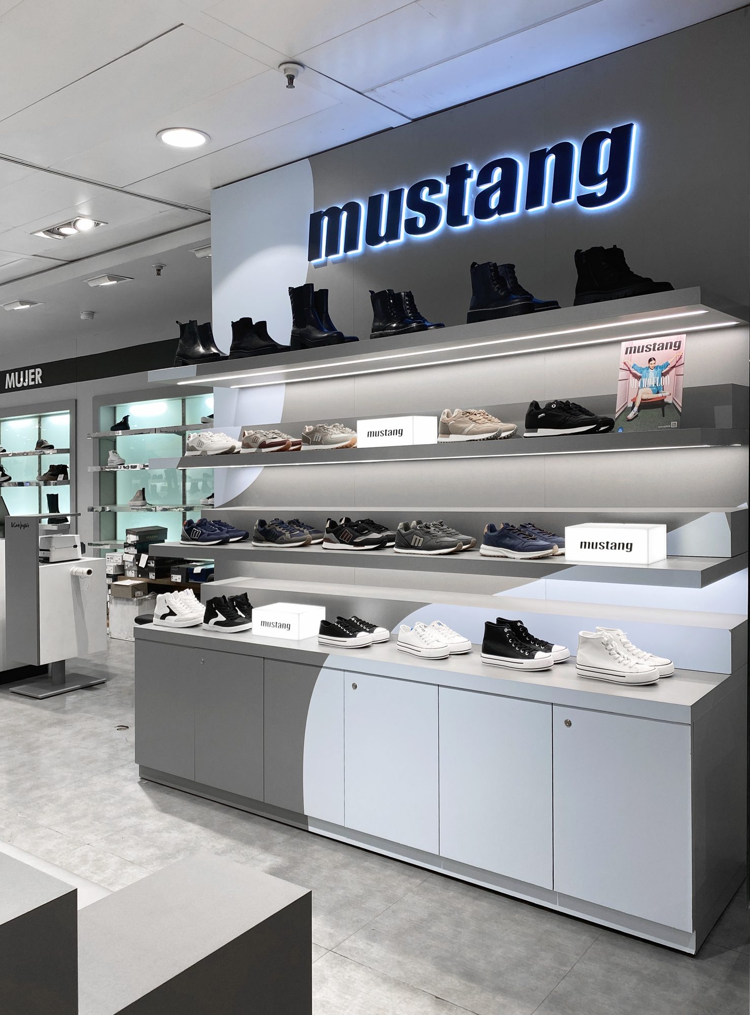Grey Mustang display wall with blue curved shapes and LED shelves