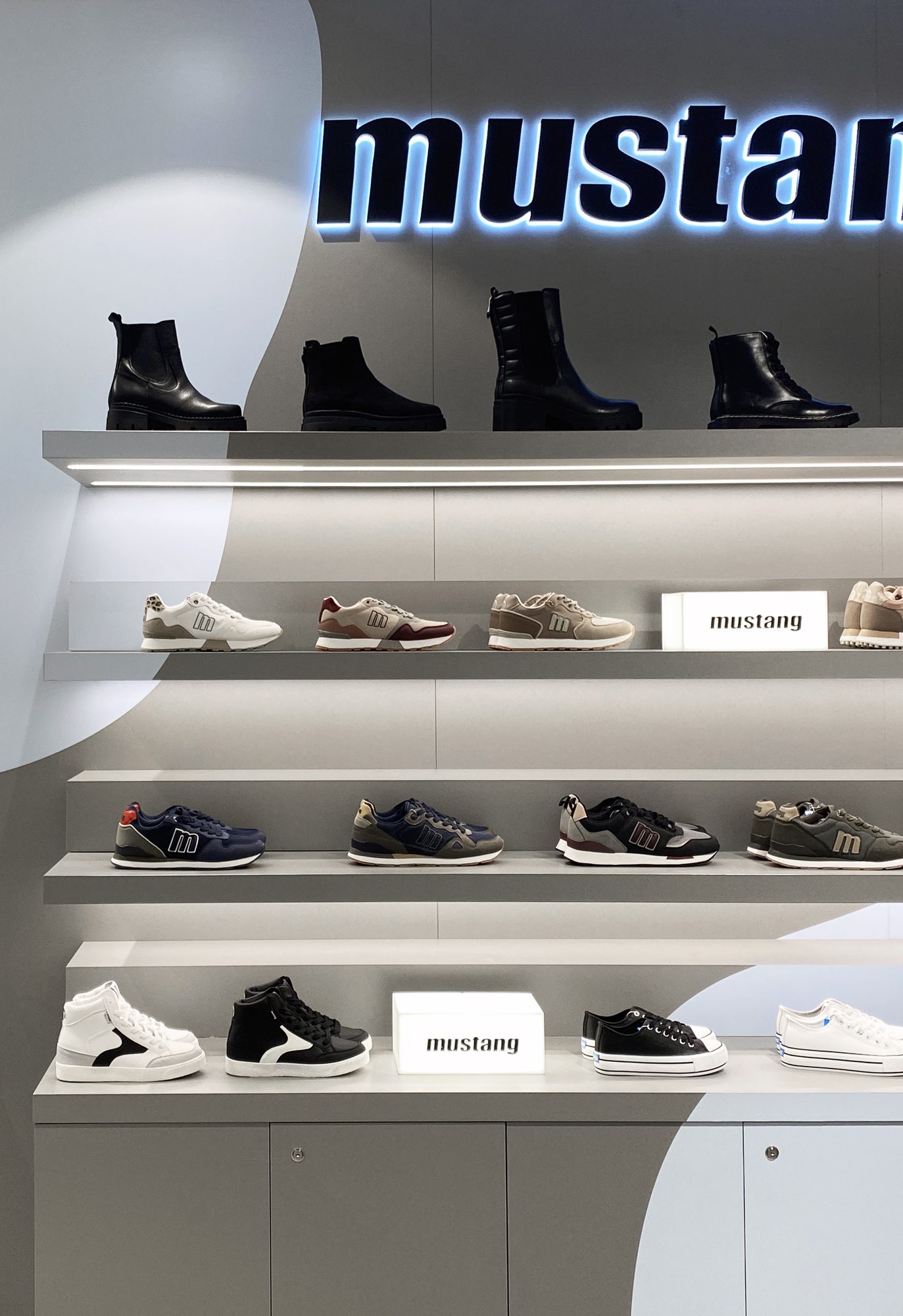 Mustang shelves with boots, sneakers and illuminated logo cubes