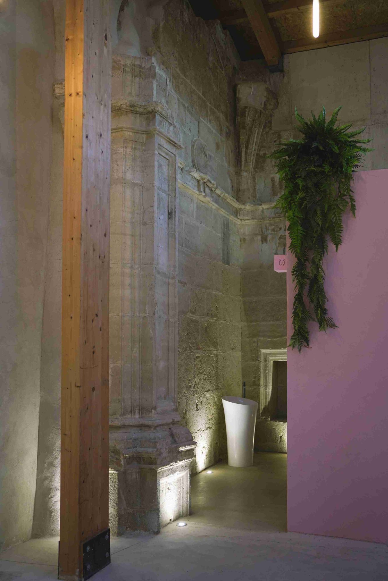 Lit stone pilaster next to the pink volume and a timber column